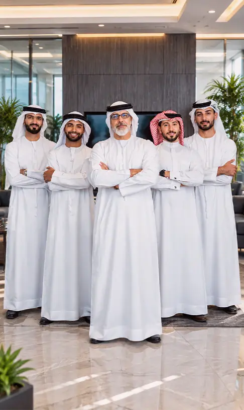 خمسة رجال بالزي الوطني الأبيض يقفون عاقدين أذرعهم على صدورهم في ردهة مكتب